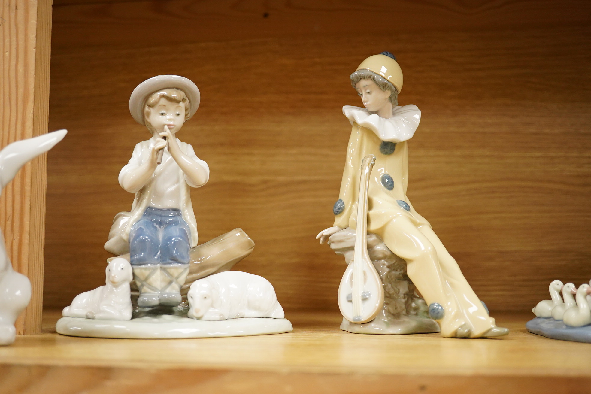 Four Lladro and Nao figures and a Doulton Toby jug, The Lawyer, largest 20cm high
